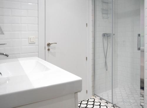 a white bathroom with a shower and a sink at Zamora Suites Central in Zamora