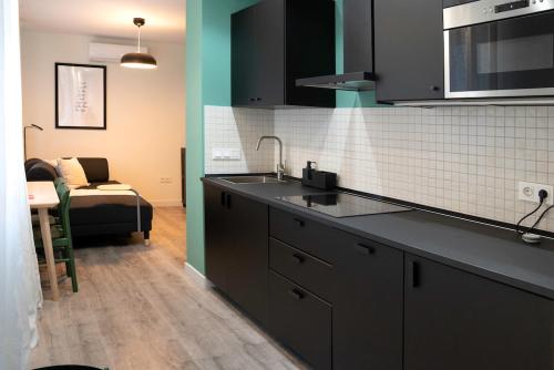 a kitchen with a sink and a couch in a room at Zamora Suites Central in Zamora