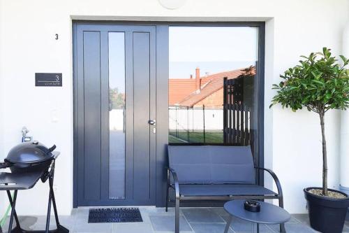 a blue door with a chair on a patio at Love Suite in Mörbisch am See
