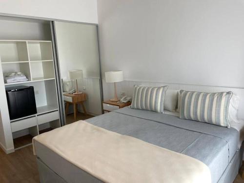 1 dormitorio con 1 cama grande y TV en Terrazas Al Mar en Pinamar