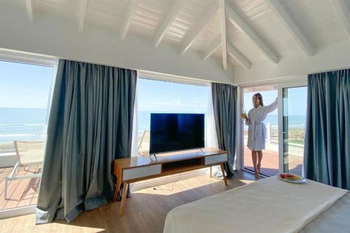 a woman standing in a bedroom with a bed and a desk at Terrazas Al Mar in Pinamar