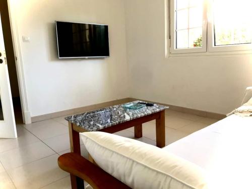 een woonkamer met een tafel en een televisie bij Apartamento céntrico en Finisterre in Fisterra