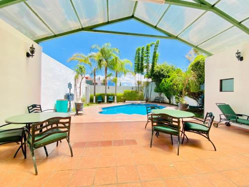 une terrasse avec des tables et des chaises ainsi qu'une piscine dans l'établissement Hotel Florencia by Marho, à Querétaro