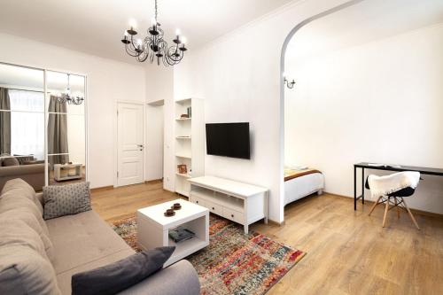 uma sala de estar com um sofá e uma televisão em Sweet Home Apartment em Lviv