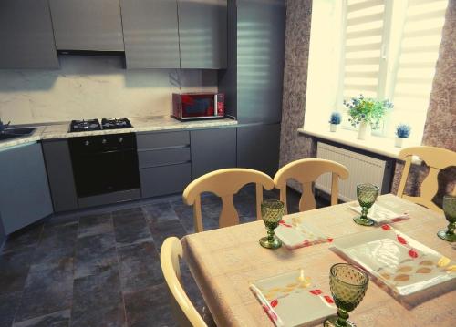a kitchen with a table and chairs and a kitchen with a stove at Комфортні Апартаменти біля Фентезі Парка in Umanʼ