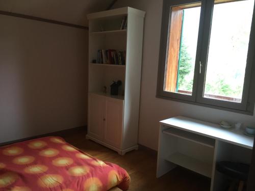 um quarto com uma cama, uma secretária e uma janela em Chambre double Futon et Chambre Classique au coeur du Vercors em Saint-Agnan-en-Vercors
