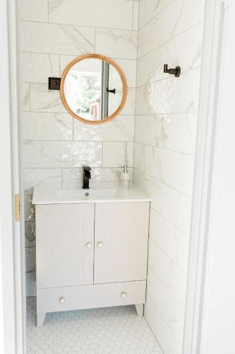 a white bathroom with a sink and a mirror at Peaceful Palace in Silla