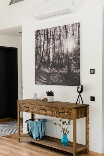 a wooden console table in a room with a painting on the wall at Peaceful Palace in Silla