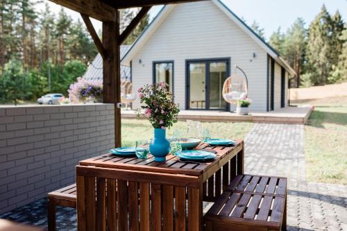 a wooden table with plates and a vase of flowers at Peaceful Palace in Silla