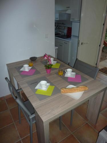 a wooden table in a kitchen with a tableablish at Villa Pinarello climatisée avec piscine chauffée in Sainte-Lucie de Porto-Vecchio