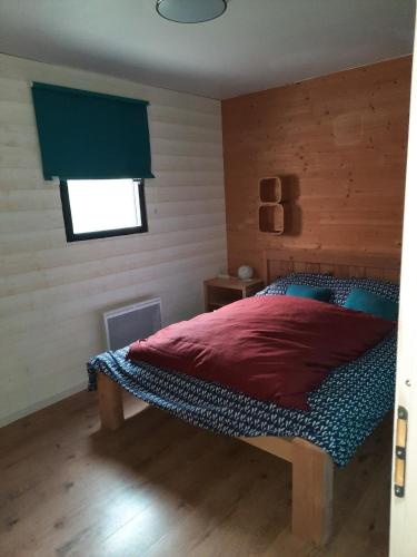 um quarto com uma cama com um edredão vermelho e uma janela em La Chouette em Bolquère - Pyrénées 2000