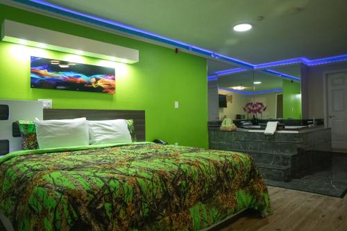 1 dormitorio con cama y pared verde en Classic Motor Lodge Providence - West Greenwich, en West Greenwich