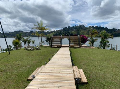 a wooden boardwalk leading to a pavilion on a lake at Jordan Hotel Boutique in Guatapé