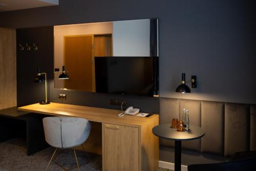 a room with a desk with a mirror and a chair at Hotel & SPA Hetman in Siedlce