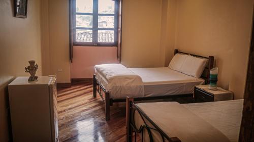 a room with two beds and a window at Hotel La Cierva de San Marcos in Quito