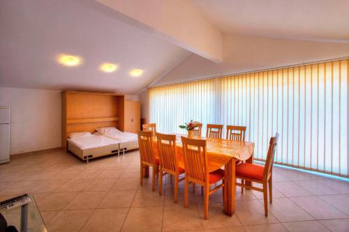 a dining room with a table and chairs and a bed at Villa D&I in Vodice