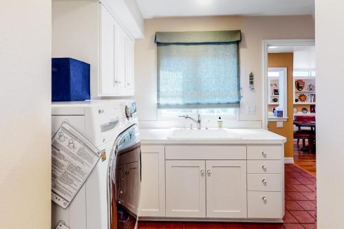 a white kitchen with a sink and a dishwasher at The Potter House in Eugene