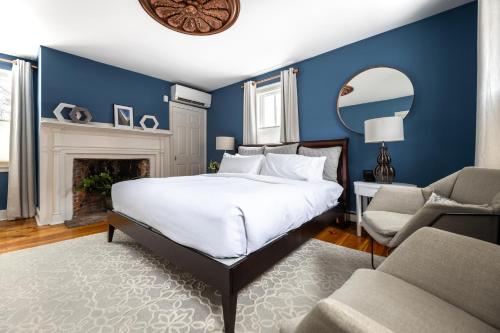 a blue bedroom with a bed and a fireplace at The Sailmaker's House in Portsmouth