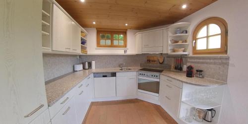 a white kitchen with white cabinets and a window at Ferienhaus Maliet - Spacious Holiday Home with Mountain view in Pany