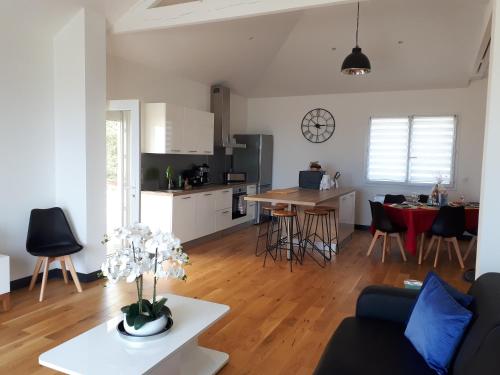 un salon et une cuisine avec un canapé et une table dans l'établissement Maison et grande terrasse face mer, à Saint-Michel-Chef-Chef