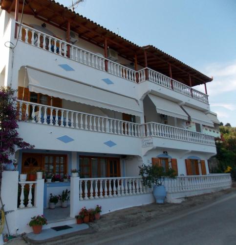 a large white building with blue arrows on it at Myriam Studios in Patitiri