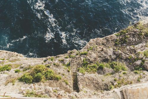 a staircase on the side of a mountain near the ocean at B&B Relais Del Senatore in Polignano a Mare