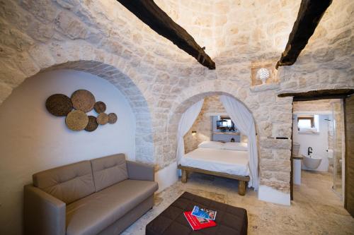 sypialnia z łóżkiem w kamiennej ścianie w obiekcie Il Trullo della Rondinina w Alberobello