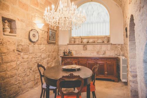 a dining room with a table and a chandelier at B&B Relais Del Senatore in Polignano a Mare