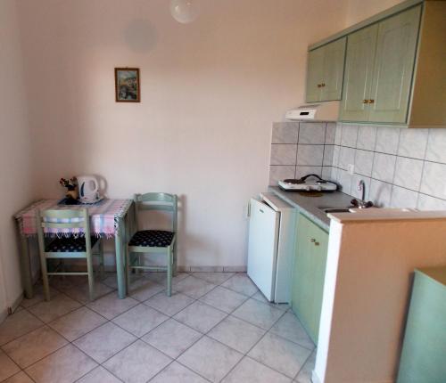 a small kitchen with a table and a sink at Myriam Studios in Patitiri