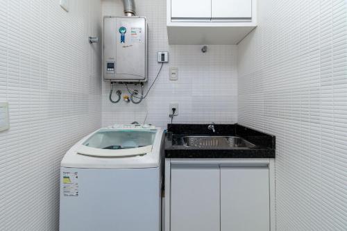 małą kuchnię ze zlewem i kuchenką mikrofalową w obiekcie Aluguel Apartamento 3 quartos vista mar Bombas SC w mieście Bombinhas