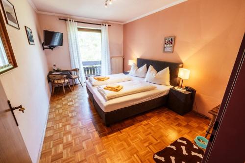 a bedroom with a bed and a table and a window at Landgasthof Zum Hammerschmied in Ranten
