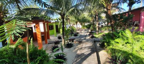 um jardim com palmeiras e um edifício em Pousada Lotus em Praia do Preá