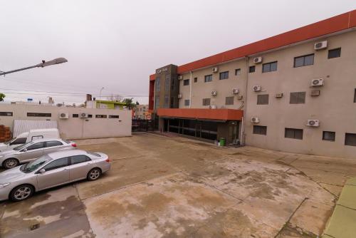 two cars parked in a parking lot in front of a building at Hotel Coé Verá in Paraná