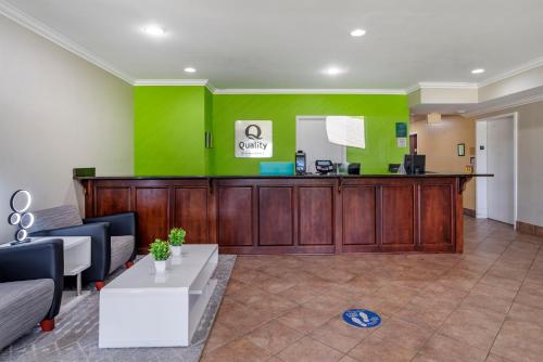 a lobby with a green accent wall and a waiting room at Quality Inn & Suites Demopolis in Demopolis