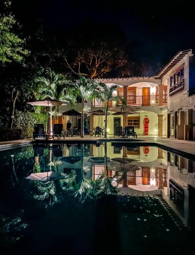 a swimming pool in front of a house at night at Finca Hotel Guali Santafe in Santa Fe de Antioquia