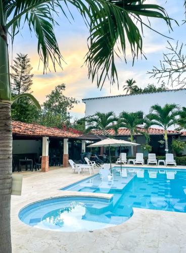 a swimming pool with chairs and a resort at Finca Hotel Guali Santafe in Santa Fe de Antioquia