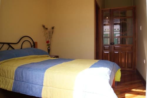 a bedroom with a bed and a wooden door at Hotel La Cierva de San Marcos in Quito