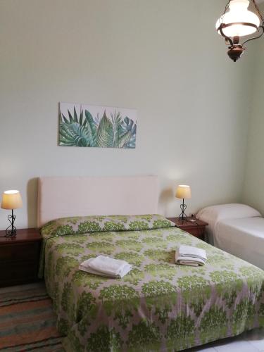 a bedroom with a bed with a green bedspread at Il Giardino Del Purgatorio in Marsala