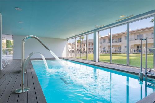 a swimming pool in a building with a building at Trendhotel Alcudia - Adults Only in Port d'Alcudia