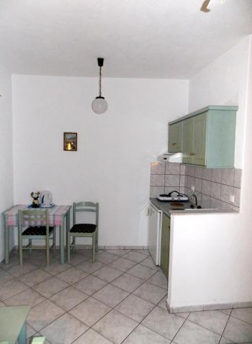 a kitchen with a table and a table and chairs at Myriam Studios in Patitiri