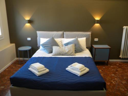 a bedroom with a blue bed with towels on it at AbitaRoom in Bologna