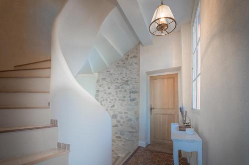 a hallway with a staircase with a table and a window at La Maison de Beaumont in Beaumont-de-Pertuis