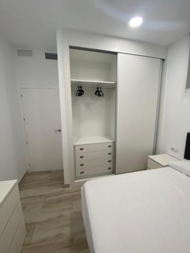 a white bedroom with a bed and a closet at Apartamentos BEACHYDAYS Montalvo in Torremolinos