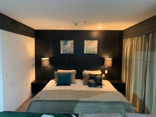 En eller flere senge i et værelse på HOTEL SHOPPING VILA OLIMPIA