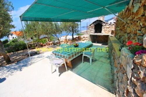a green table and chairs under a green umbrella at Apartman SPOT in Drašnice