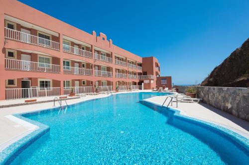 un hotel con piscina frente a un edificio en Casa Wind, en Costa Calma