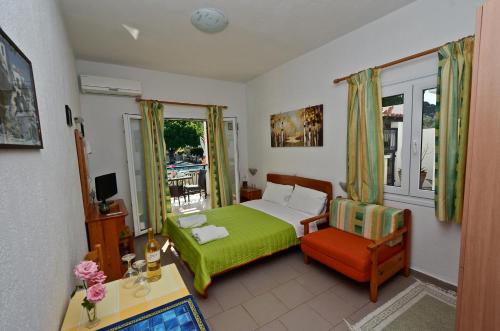 ein Schlafzimmer mit einem Bett, einem Stuhl und einem Fenster in der Unterkunft Pegasus Apartments in Stafylos