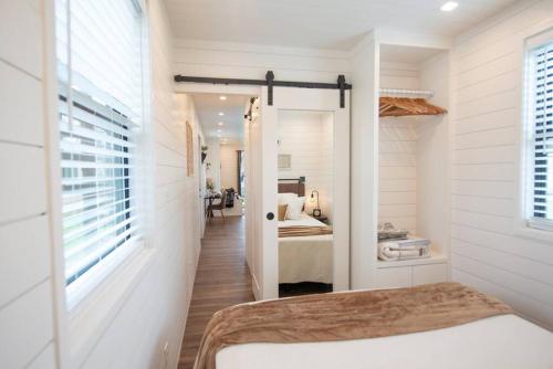 a white bedroom with a bed and a bedroom with a bed sqor at The Newtonian Tiny Container Home near Magnolia in Bellmead