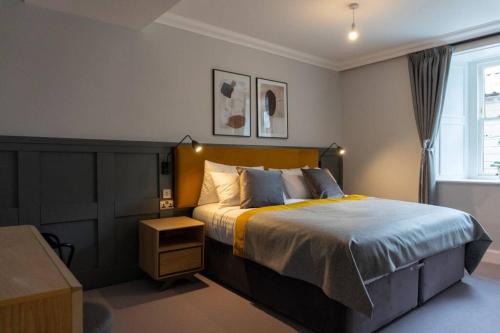 a bedroom with a large bed and a window at Argyle Square Apartment in Oban