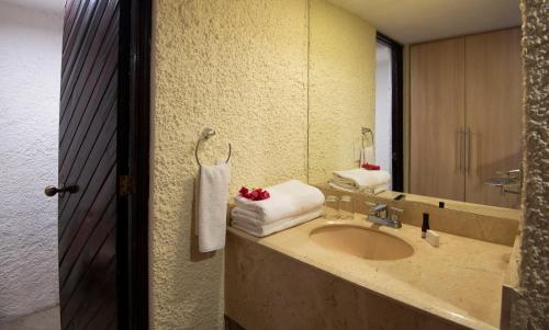 a bathroom with a sink and a mirror at Cabo Blanco Hotel and Marina in Barra de Navidad